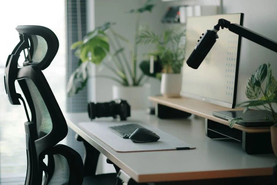High-angle view of a stylish work desk featuring dual monitors, keyboard, mouse, and modern accessories.